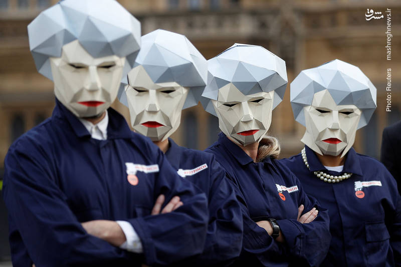 افرادی از سندیکای کارگری GMB در اعتراض به بودجه‌ریزی وزیردارایی فیلیپ هاموند، مقابل پارلمان بریتانیا تجمع کرده و ماسک معروف به «ربات می» را که از چهره نخست‌وزیر برگرفته شده به سر کرده‌اند.