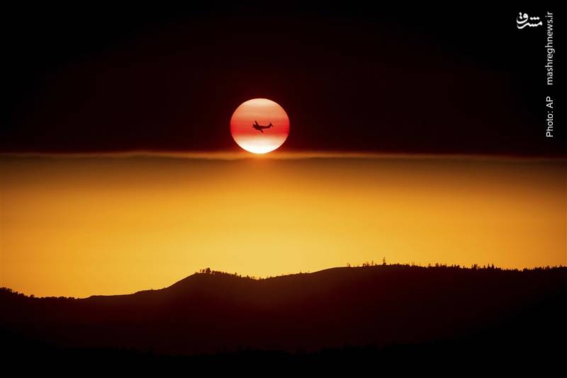 جت امداد، خورشیدی که در حال غروب است و دودی که از آتش جنگل‌های کالیفرنیا آسمان را پوشانده است.